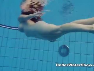 Redheaded skjønnhet svømming naken i den basseng